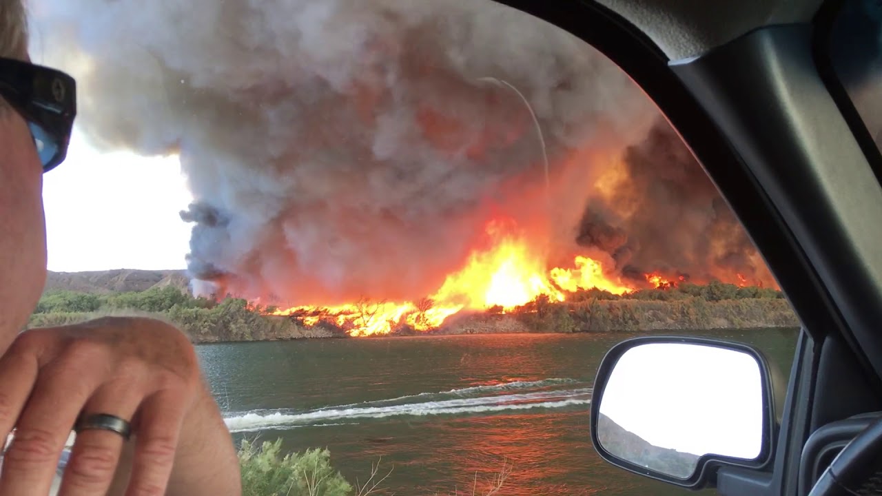 Pareja filma formación de un tornado de fuego con humo tóxico negro